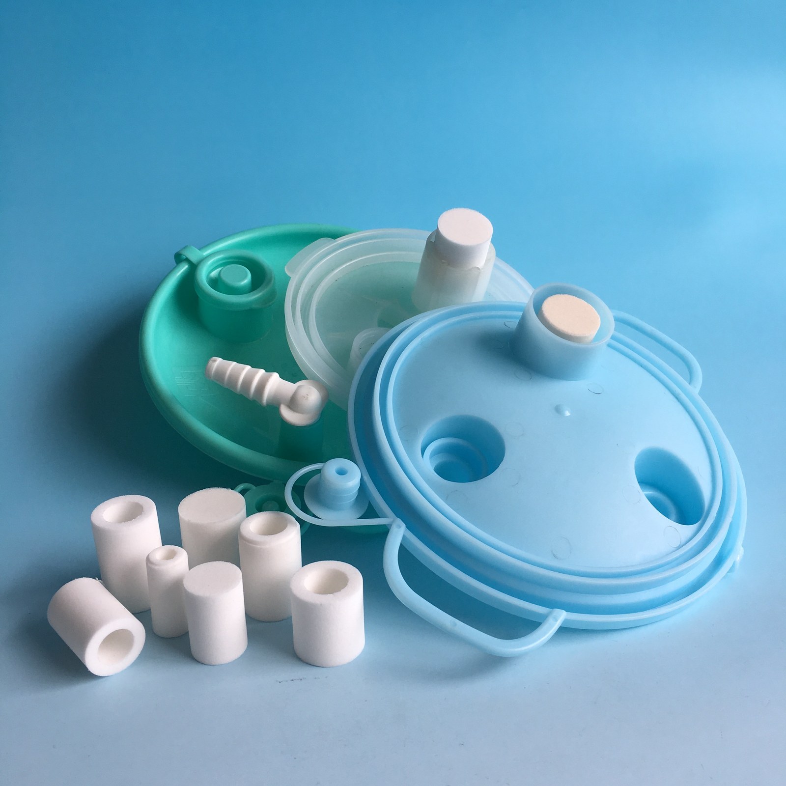 Anti-spill sintered filter elements and drainage bottle cap assemblies